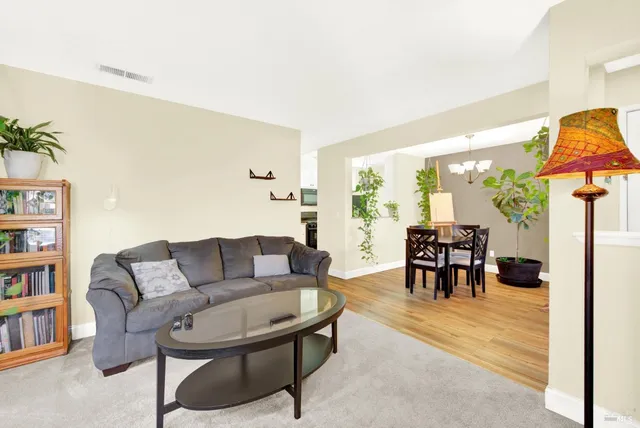 a living room with furniture and a dining table