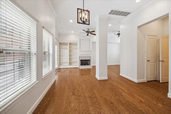 a view of empty room with wooden floor and windows