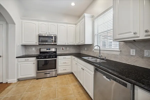 a kitchen with a refrigerator and a stove top oven