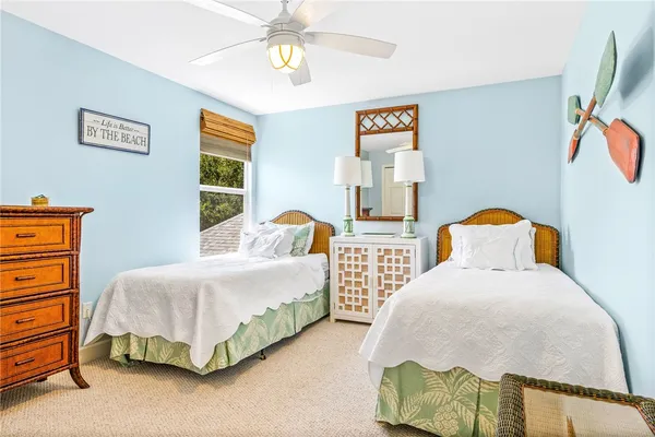 a bedroom with two beds and a chandelier