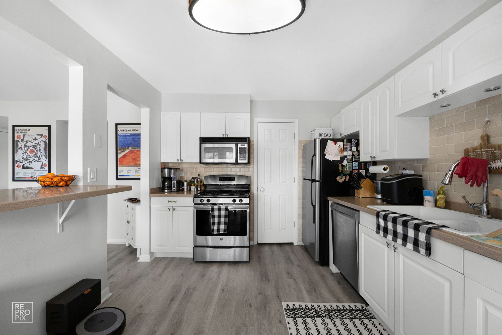 1588 Burr Oak Court, Unit B Wheaton, IL 60189 - Photo 5 of 10 a kitchen with stainless steel appliances a stove a refrigerator and cabinets