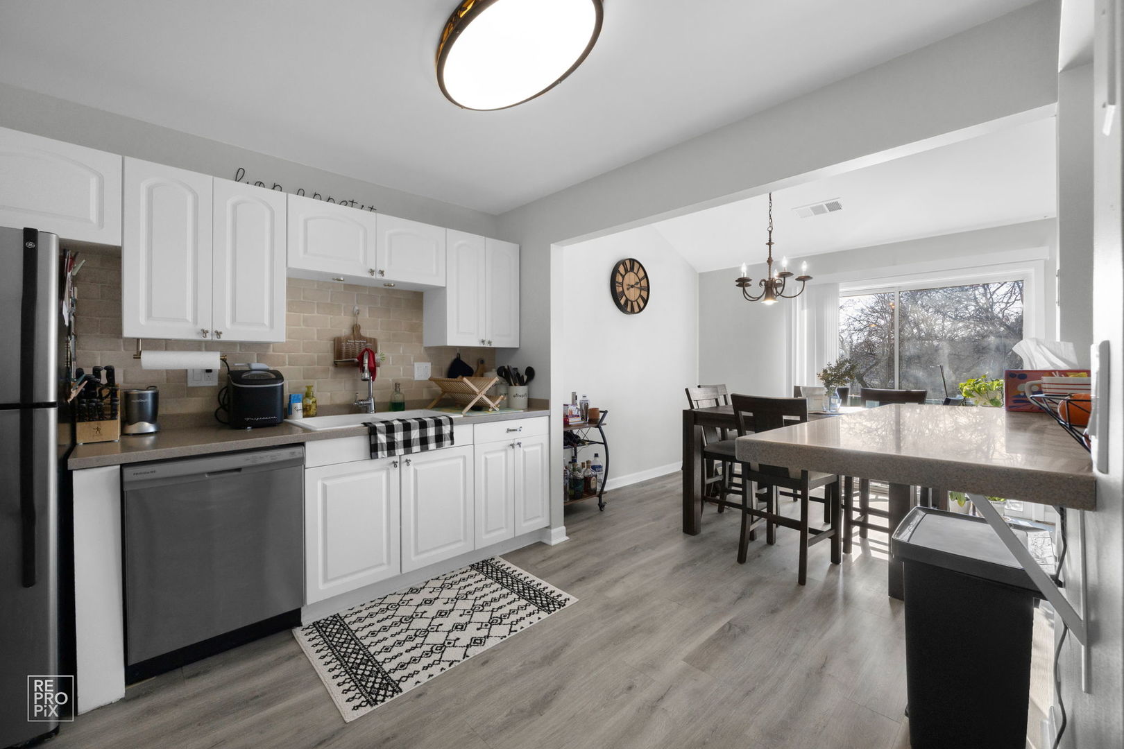 1588 Burr Oak Court, Unit B Wheaton, IL 60189 - Photo 6 of 10 a kitchen with a dining table chairs and refrigerator