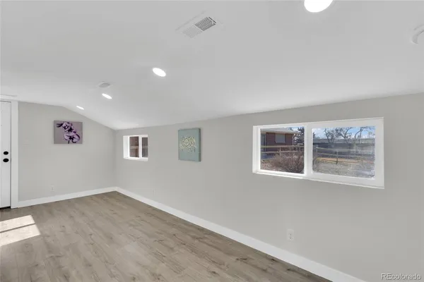 an empty room with windows and furniture