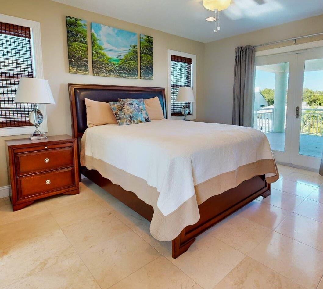 131 Coco Plum Road South Key Largo, FL 33037 - Photo 14 of 19 a bed sitting in a bedroom next to a window