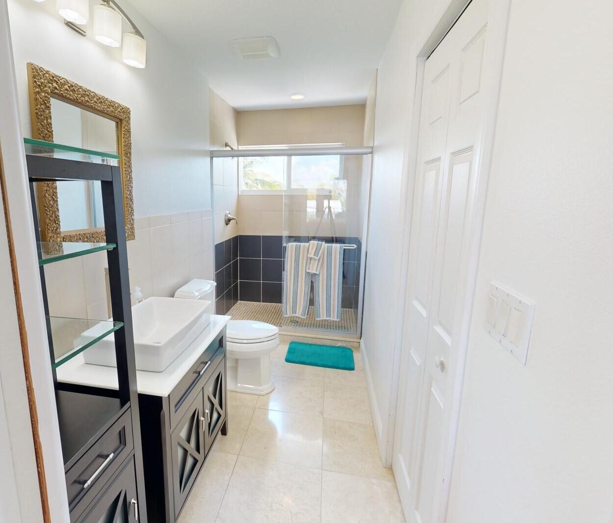 131 Coco Plum Road South Key Largo, FL 33037 - Photo 15 of 19 a bathroom with a sink a toilet and a mirror