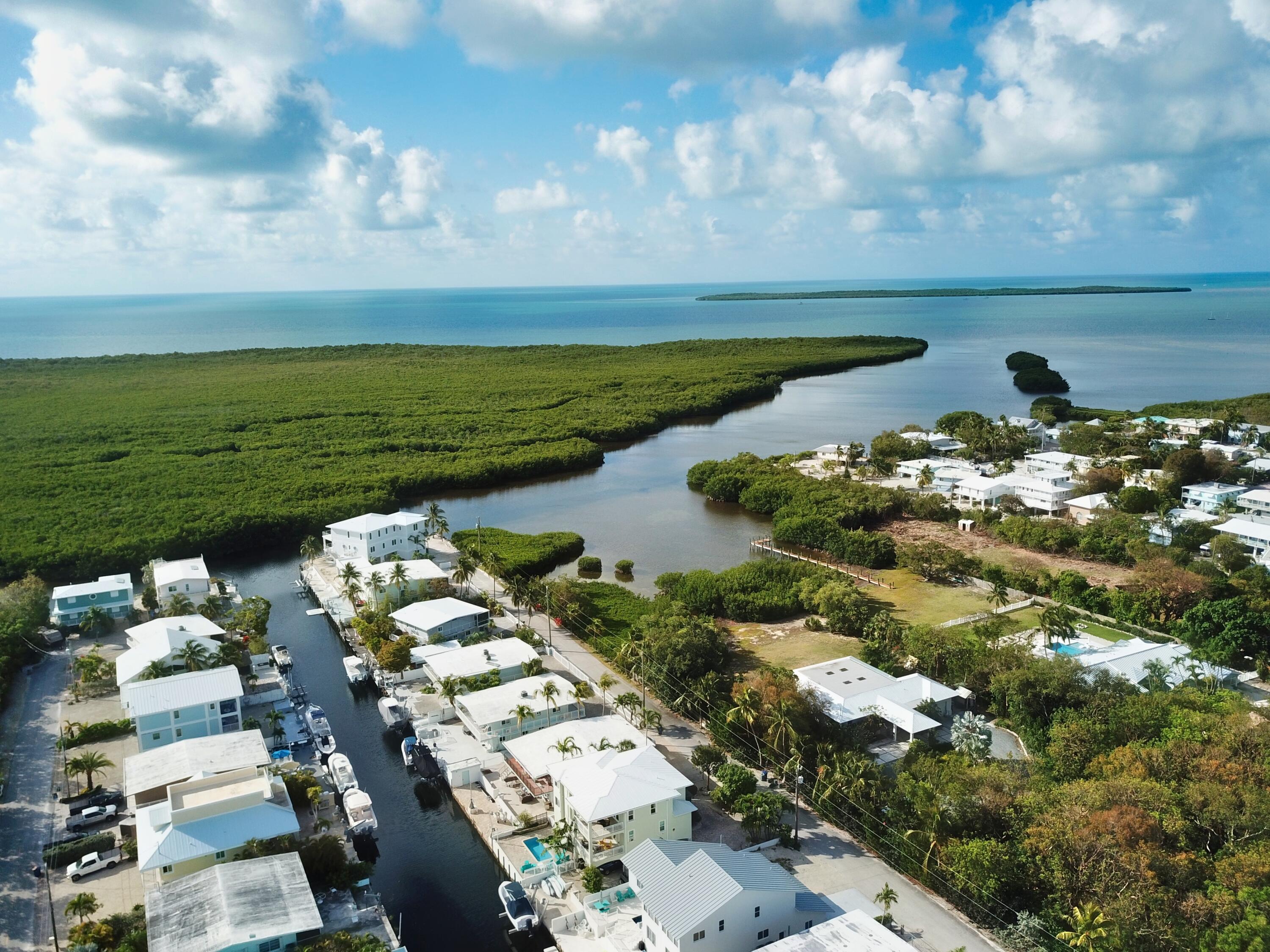 131 Coco Plum Road South Key Largo, FL 33037 - Photo 2 of 19 a view of a lake with lawn chairs