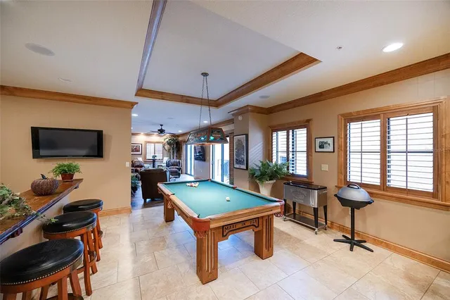 a room with pool table and windows