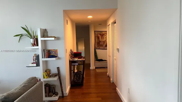 a view of a hallway to a livingroom with furniture