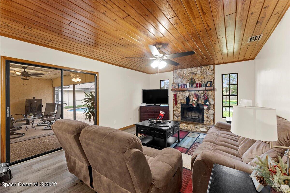 3205 Westland Melbourne, FL 32934 - Photo 5 of 55 a living room with furniture a flat screen tv and a floor to ceiling window