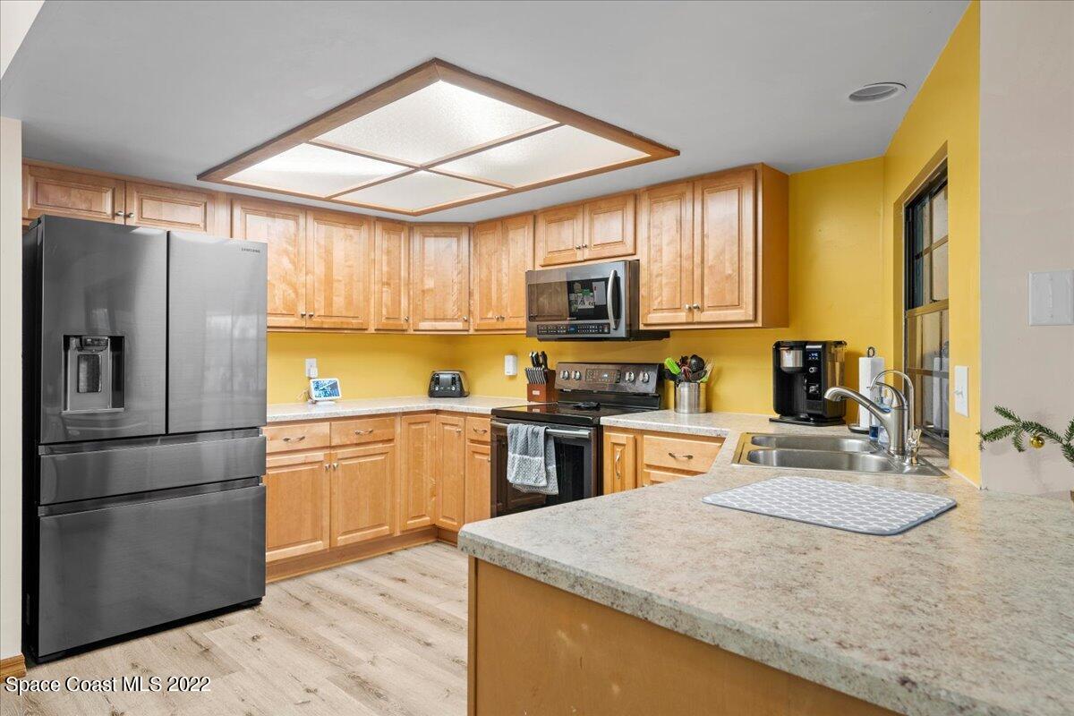 3205 Westland Melbourne, FL 32934 - Photo 6 of 55 a kitchen with kitchen island granite countertop a sink appliances cabinets and a counter top space