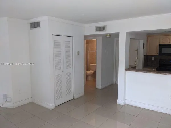 a view of a hallway with wooden floor and a bathroom