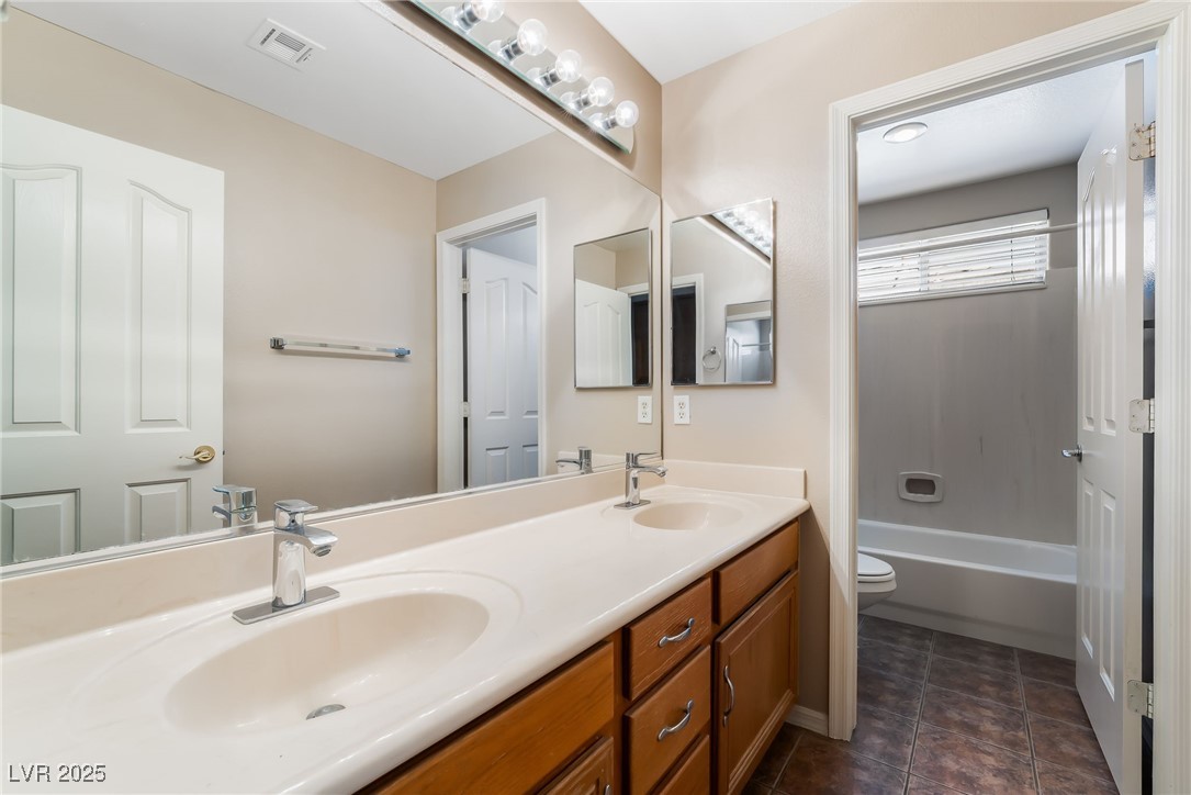 2392 Rainswept Avenue Henderson, NV 89052 - Photo 36 of 49 Bathroom featuring visible vents, a sink, double vanity, and toilet