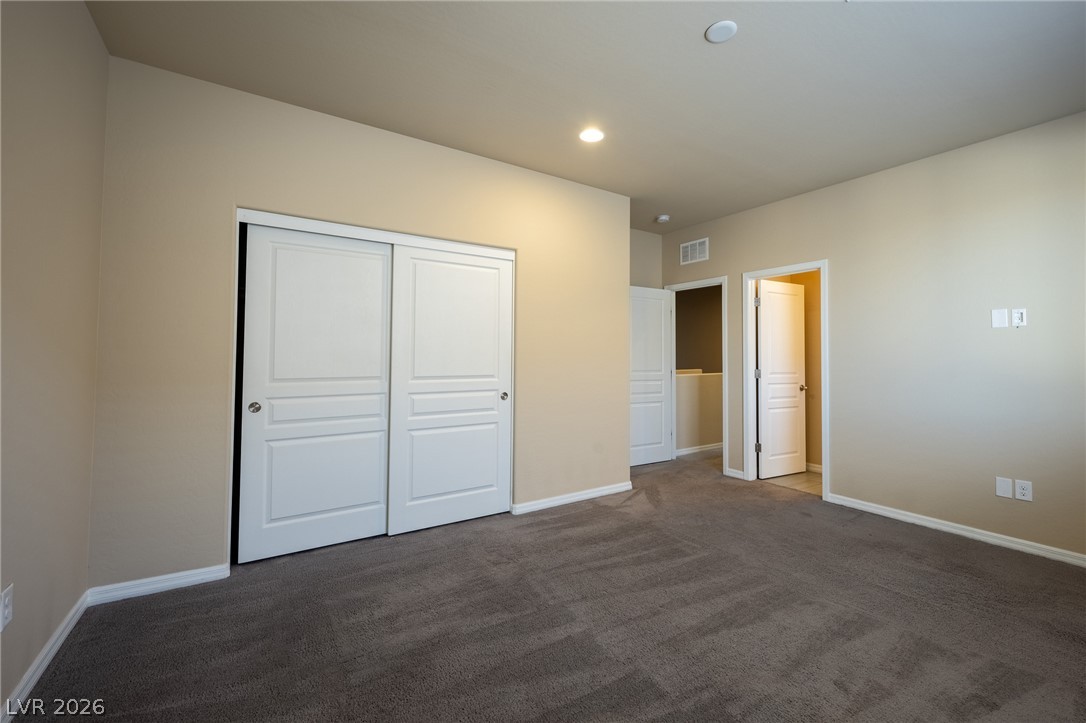 11016 Prairie Grove Road Las Vegas, NV 89179 - Photo 24 of 37 A spacious secondary bedroom with ample closet storage and soft carpet, ready for personalization.