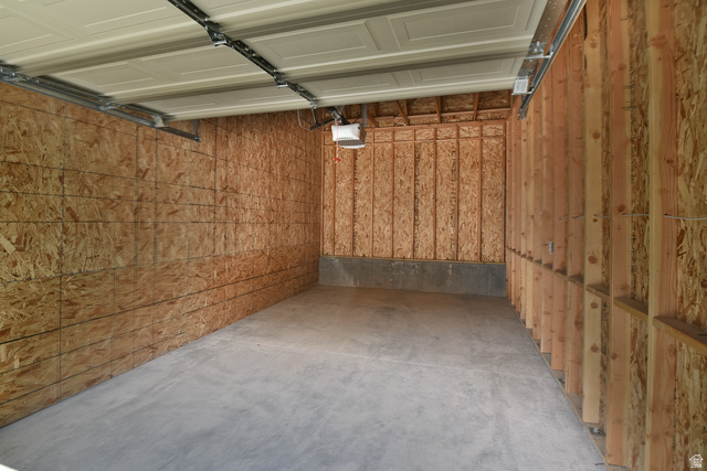 241 West Ridge Road Saratoga Springs, UT 84045 - Photo 19 of 21 Spacious garage with concrete flooring, exposed wood-finish walls, and an automatic garage door opener