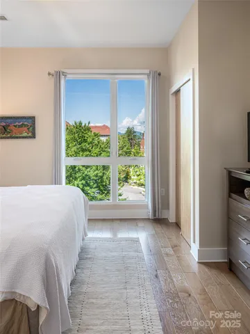 a bedroom with a bed and a large window
