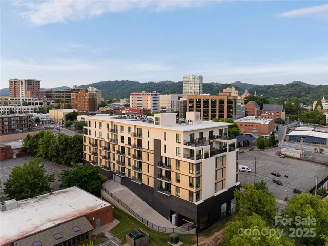 a view of a city from a balcony with chairs
