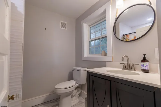 a bathroom with a sink a toilet and a mirror