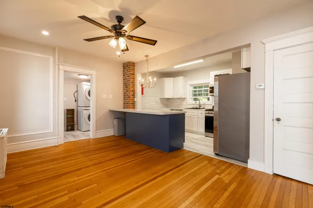 a kitchen with stainless steel appliances kitchen island granite countertop a refrigerator and a sink
