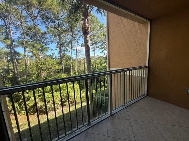 a view of a balcony with wooden floor and fence