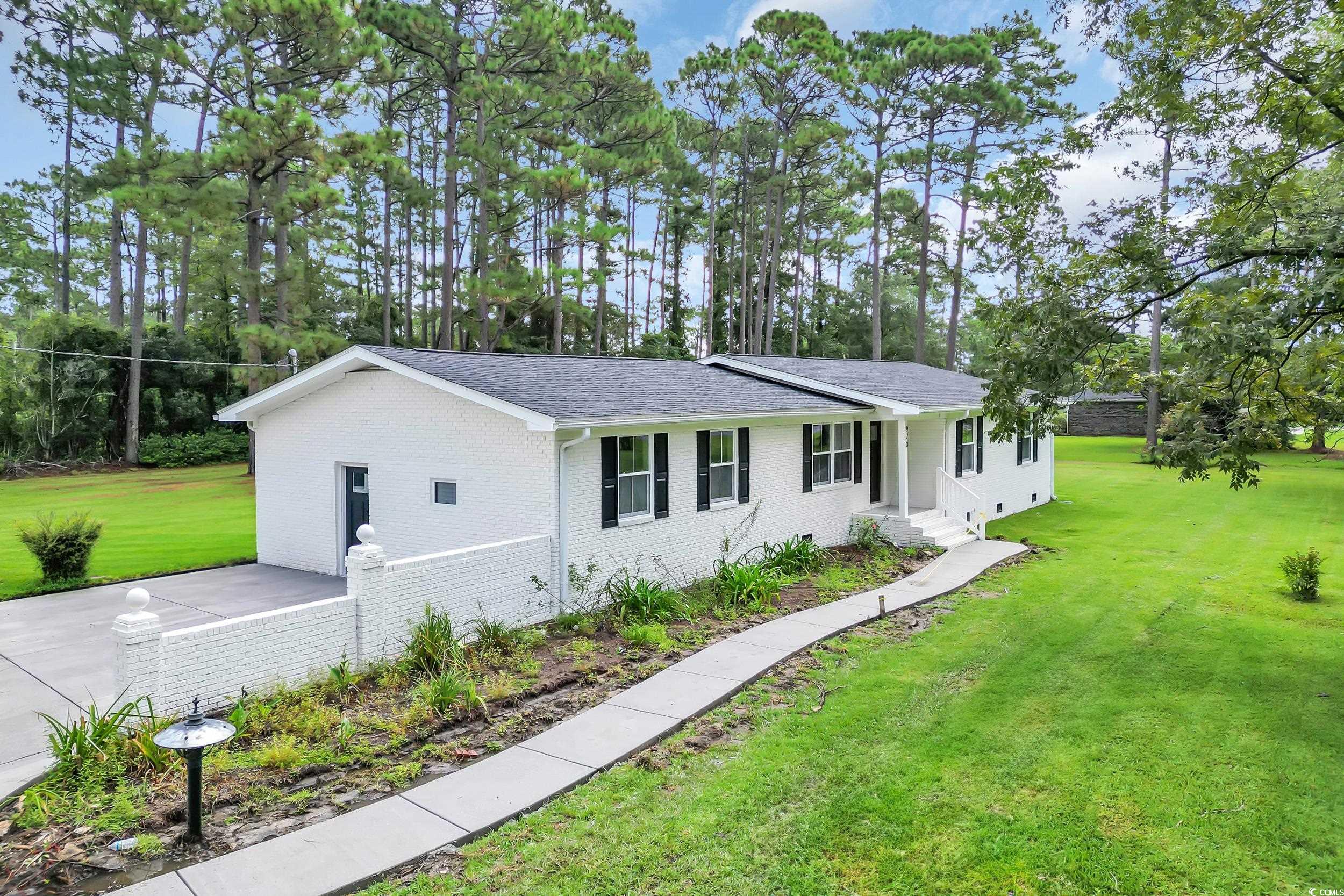 970 Virginia Drive Loris, SC 29569 - Photo 19 of 28 Ranch-style home featuring a front yard, brick siding, a shingled roof, and view of wooded area