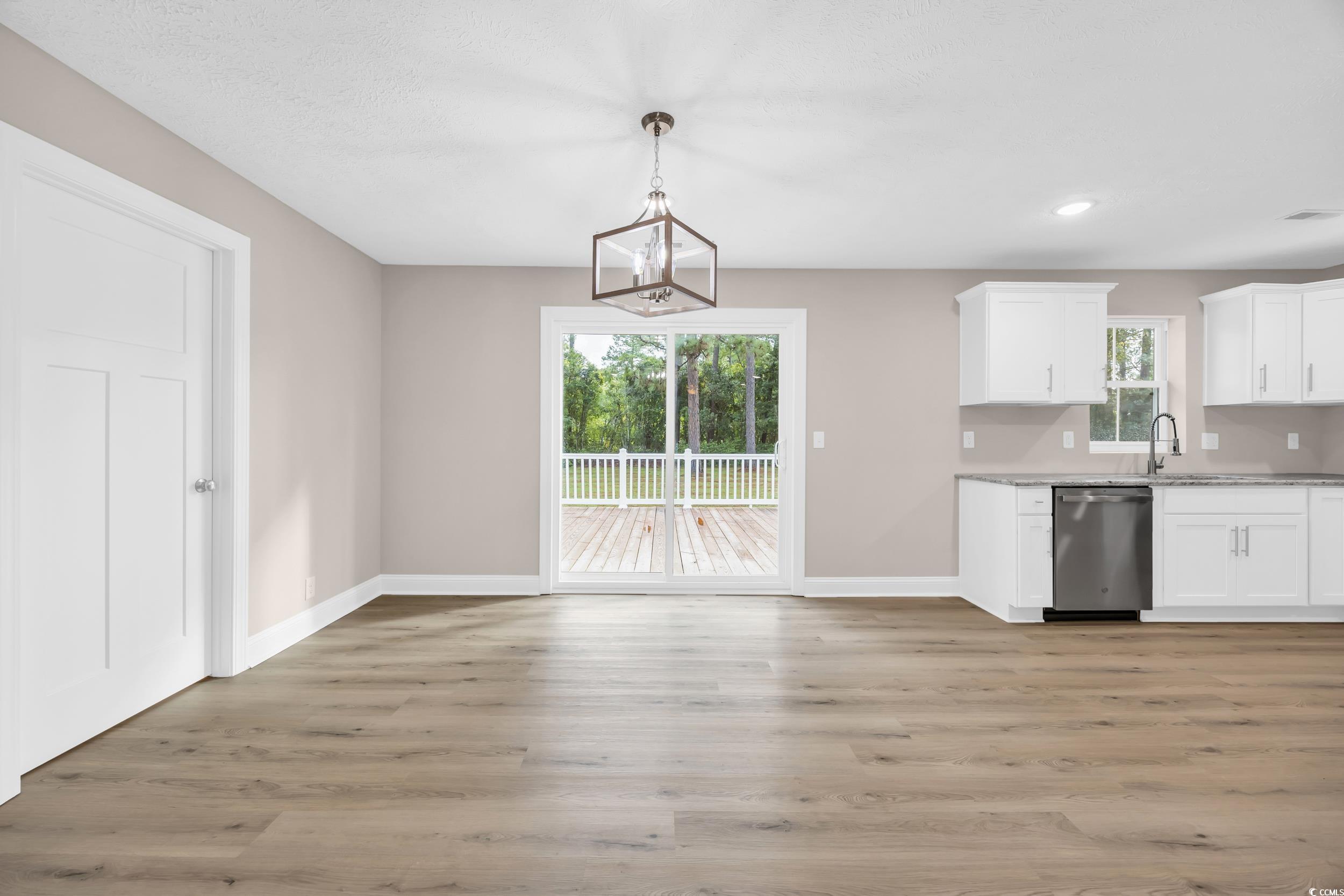 970 Virginia Drive Loris, SC 29569 - Photo 6 of 28 Kitchen featuring white cabinetry, light wood finished floors, pendant lighting, dishwasher, and light stone counters