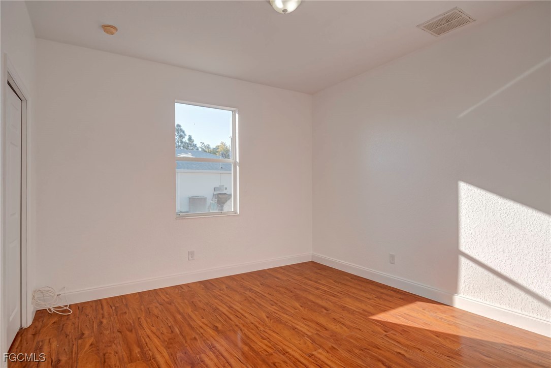 3605 17th Street West Lehigh Acres, FL 33971 - Photo 20 of 27 an empty room with wooden floor and windows
