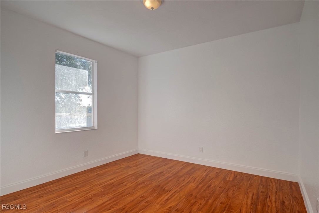 3605 17th Street West Lehigh Acres, FL 33971 - Photo 21 of 27 an empty room with wooden floor and windows