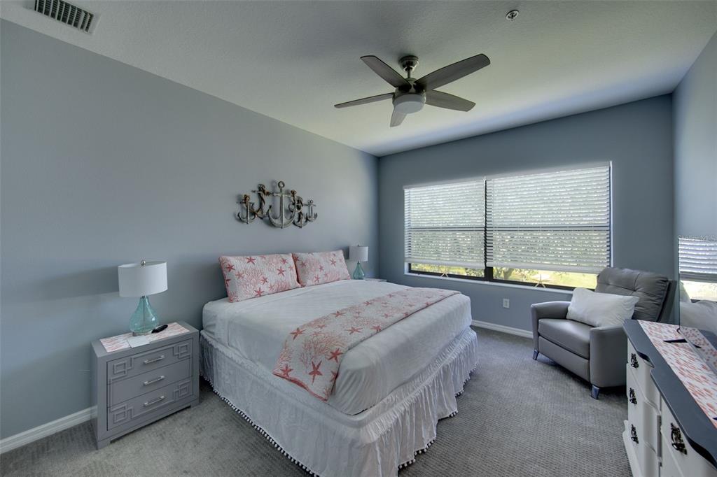 4026 Overture Circle Bradenton, FL 34209 - Photo 10 of 26 a spacious bedroom with a bed a couch and a large window