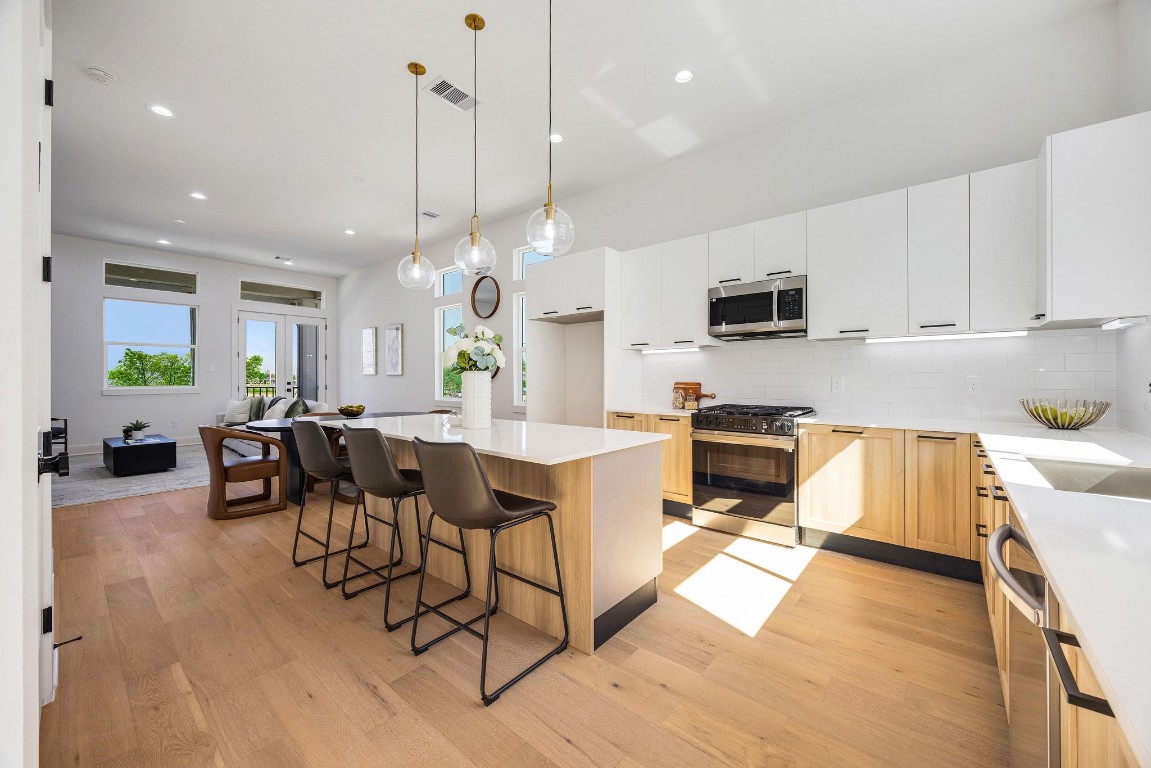 Sleek, modern kitchen with stainless steel appliances, elegant Italian cabinetry, soft closing cabinets/drawers, and a spacious island perfect for entertaining.
