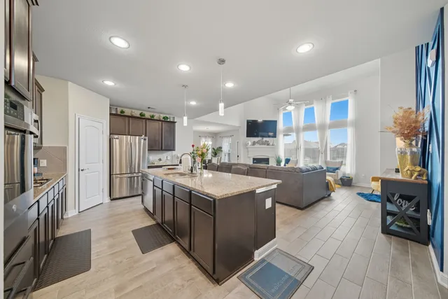 a kitchen with stainless steel appliances granite countertop a sink stove and refrigerator