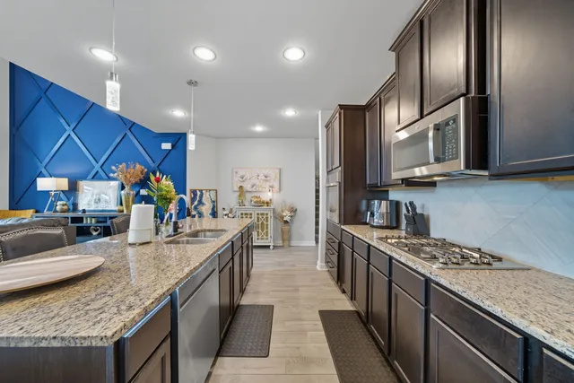 a kitchen with stainless steel appliances granite countertop a sink stove and refrigerator
