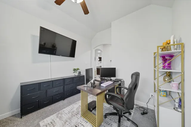 a view of a workspace with furniture and a flat screen tv