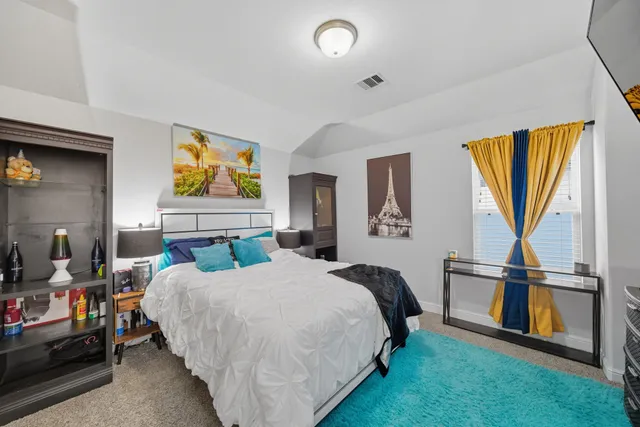 a bedroom with a bed and a view of kitchen