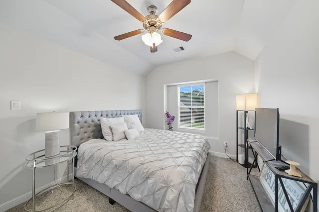 a bedroom with a large bed and a chandelier