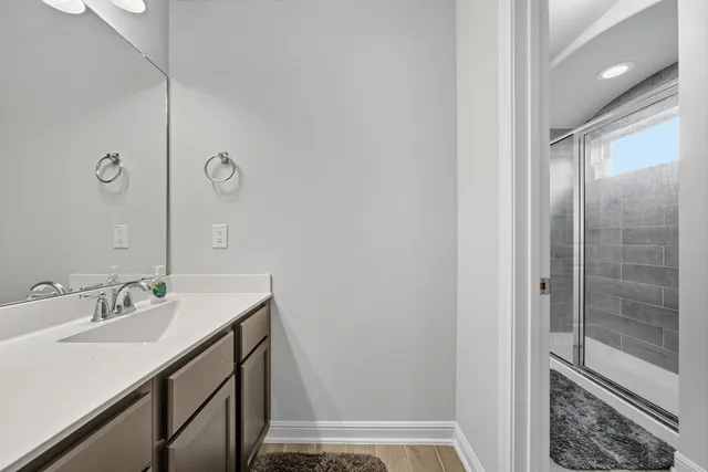 a bathroom with a sink a mirror and a shower