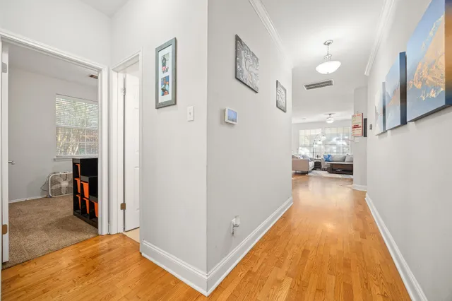 a view of a hallway with wooden floor and a living room