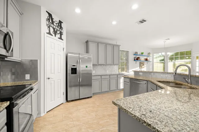a kitchen with stainless steel appliances granite countertop a sink stove and refrigerator