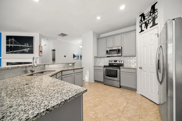 a kitchen with stainless steel appliances granite countertop a refrigerator stove microwave and sink