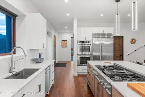 a kitchen with stainless steel appliances kitchen island granite countertop a sink stove and refrigerator