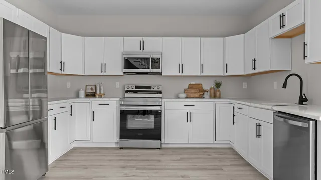 a kitchen with cabinets stainless steel appliances and sink