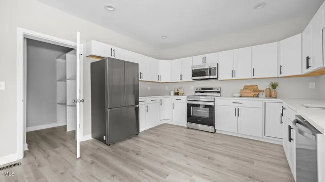 a kitchen with a refrigerator stove and wooden cabinets