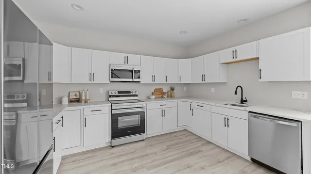 a kitchen with cabinets stainless steel appliances and sink