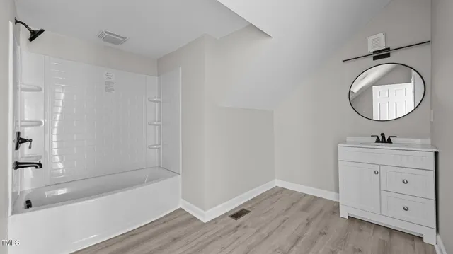 a bathroom with a sink a bathtub and a mirror