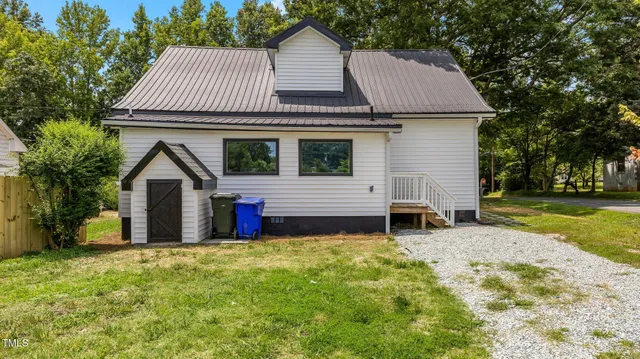 a front view of a house with a garden and yard