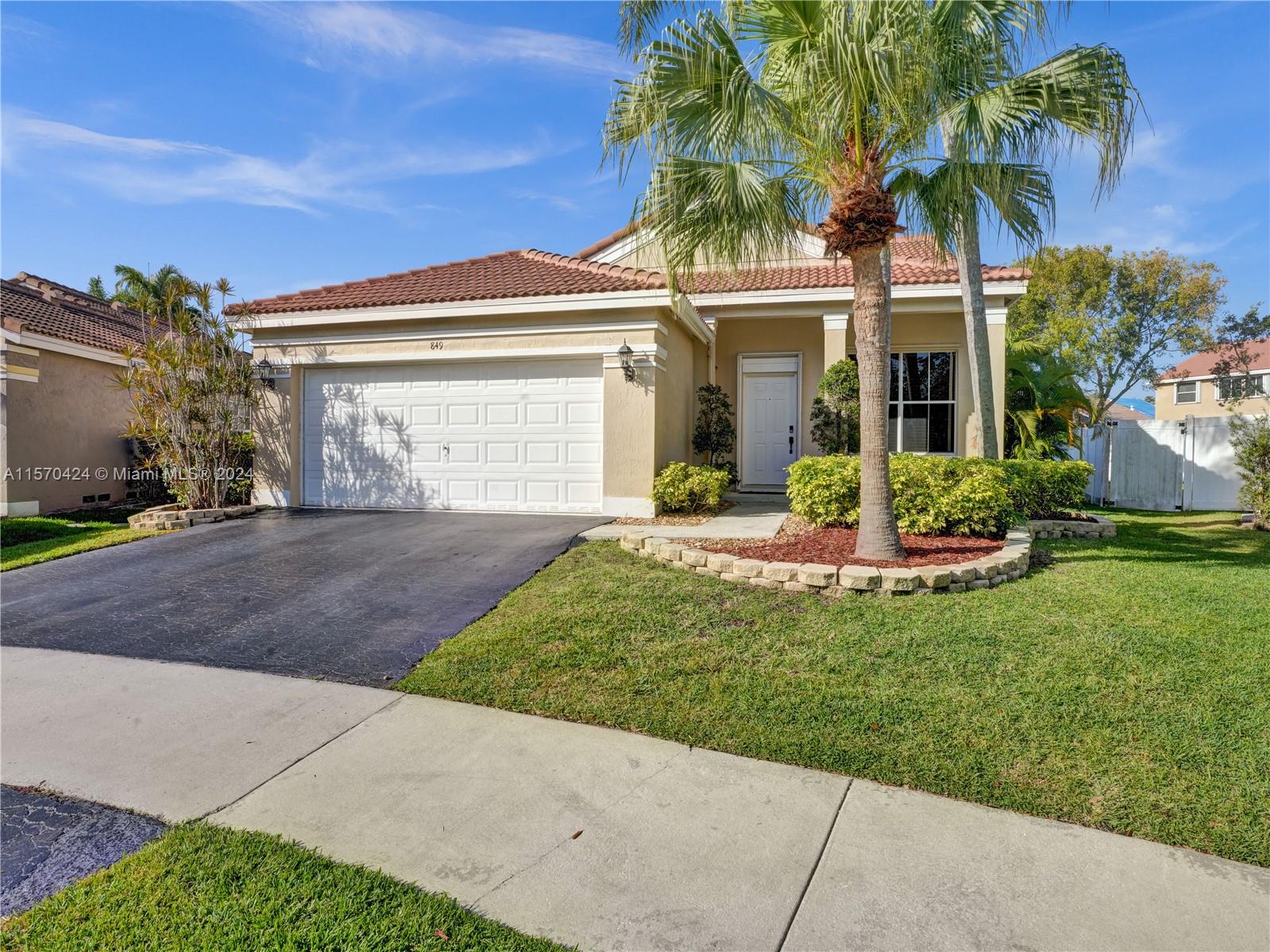 849 Falling Water Road Weston, FL 33326 - Photo 1 of 25 a front view of a house with a yard and garage