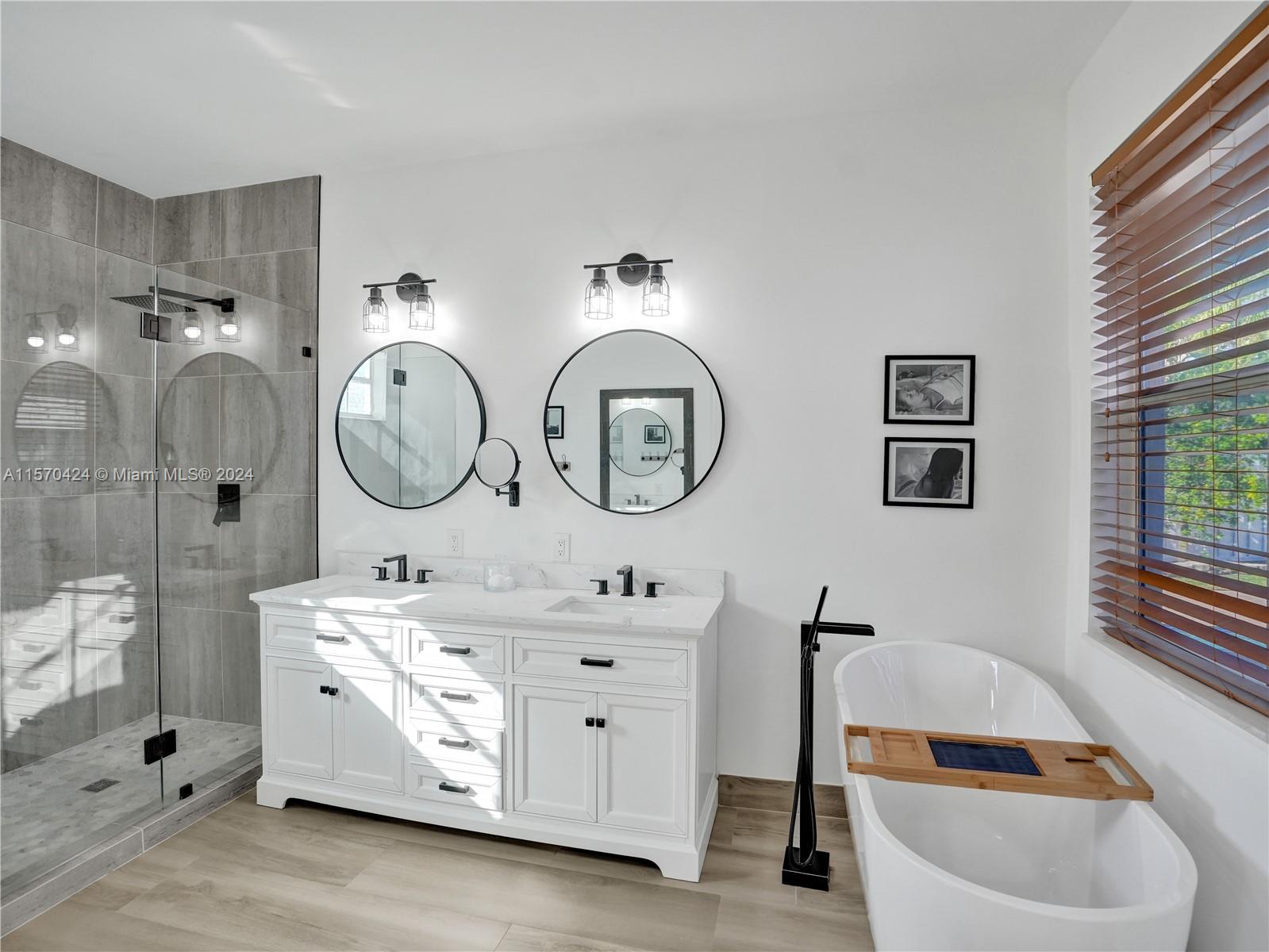 849 Falling Water Road Weston, FL 33326 - Photo 12 of 25 a bathroom with a double vanity sink a mirror a bathtub and shower