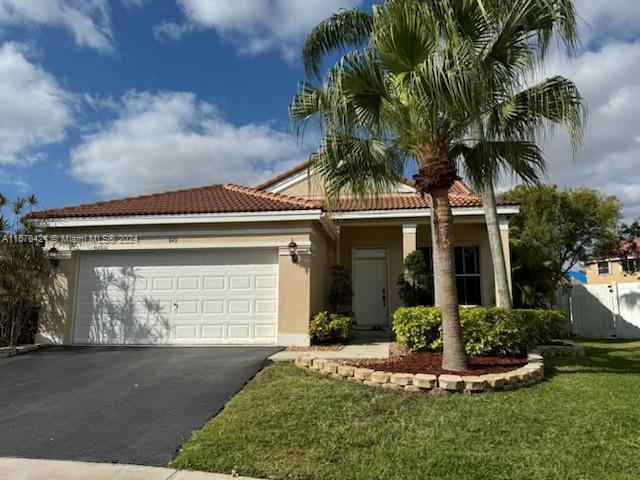 849 Falling Water Road Weston, FL 33326 - Photo 2 of 25 a front view of a house with a yard and garage