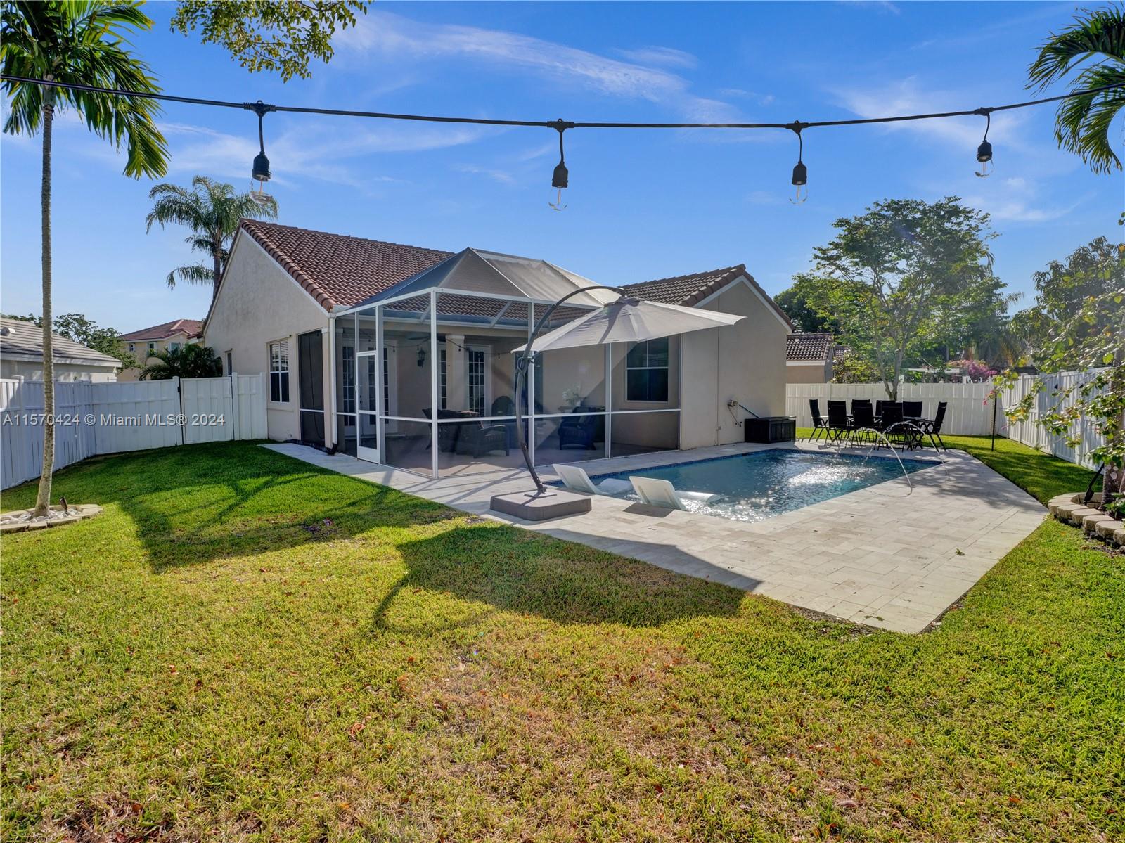 849 Falling Water Road Weston, FL 33326 - Photo 23 of 25 a front view of a house with a yard table and chairs