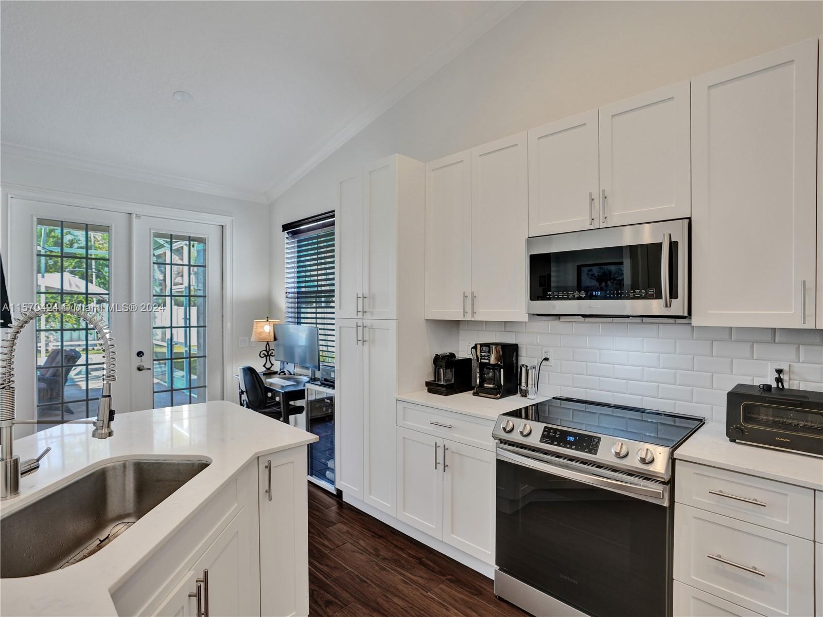 849 Falling Water Road Weston, FL 33326 - Photo 5 of 25 a kitchen with stainless steel appliances granite countertop white cabinets a sink and a stove