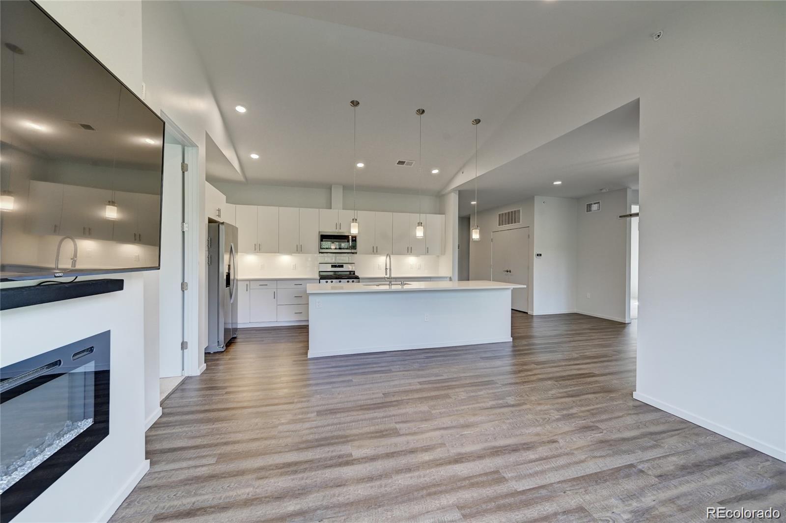 31191 Black Eagle Drive, Unit 301 Evergreen, CO 80439 - Photo 14 of 35 a view of kitchen with kitchen island granite countertop wooden floor stainless steel appliances and cabinets